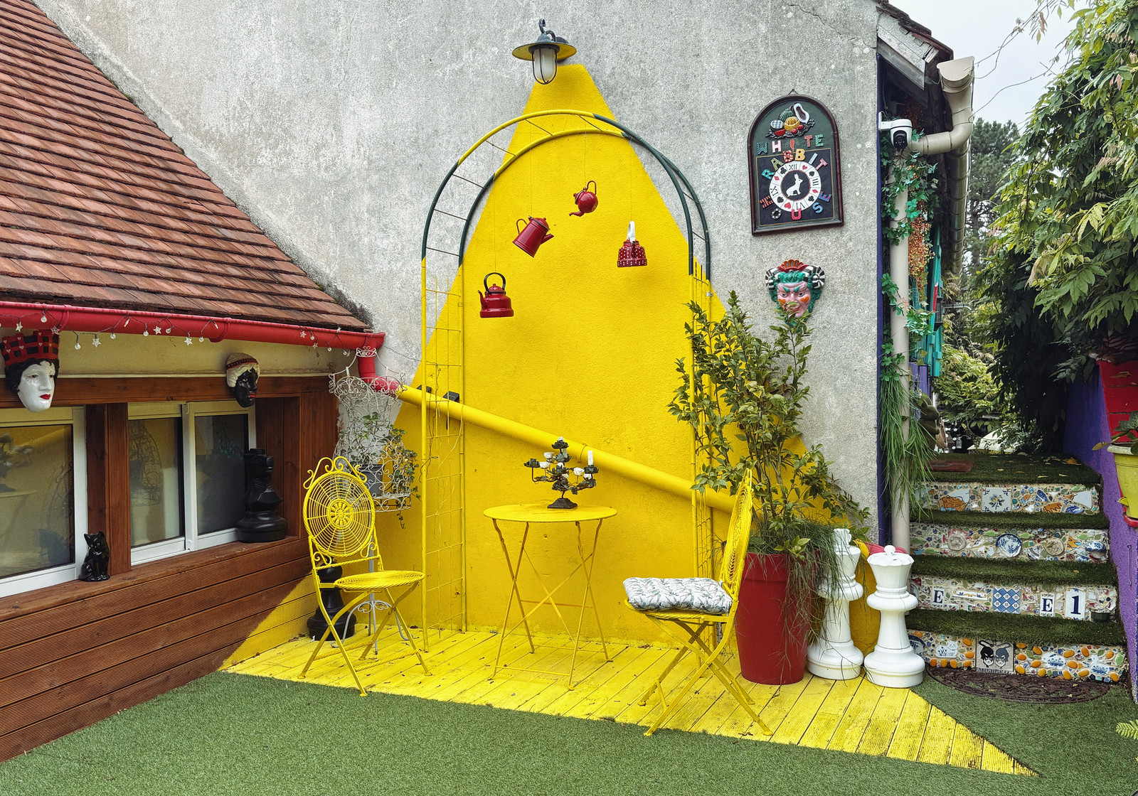 Façade jaune originale de la Maison d'Alice avec terrasse et décorations fantaisistes — chambre d'hôte Wonderland21 près de Disneyland Paris